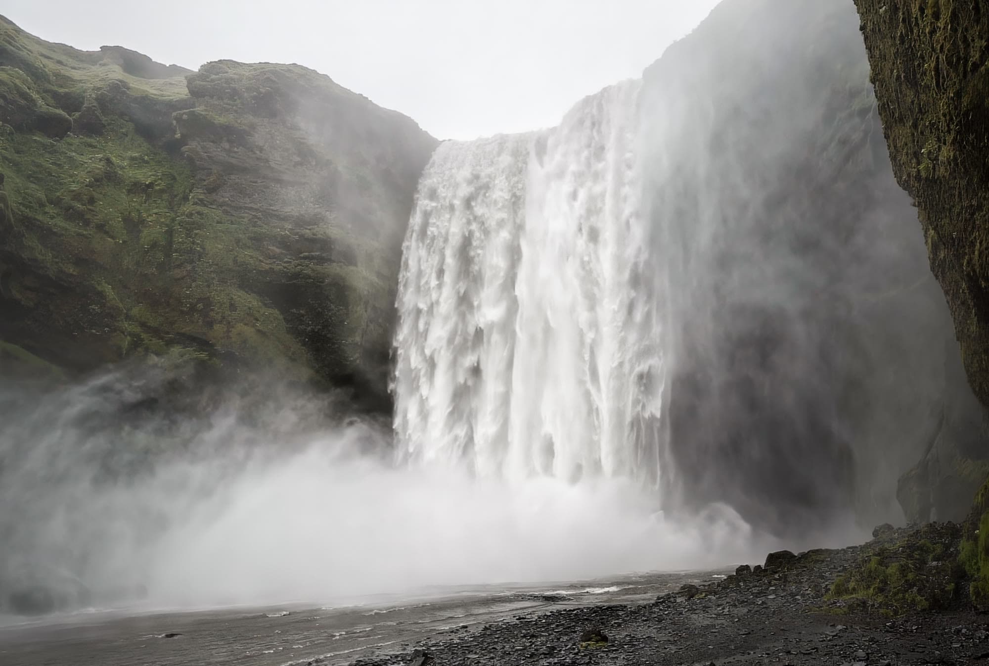 Spray de la cascada Skógafoss empapando a los visitantes, sur de Islandia — agua en suspensión, no vapor