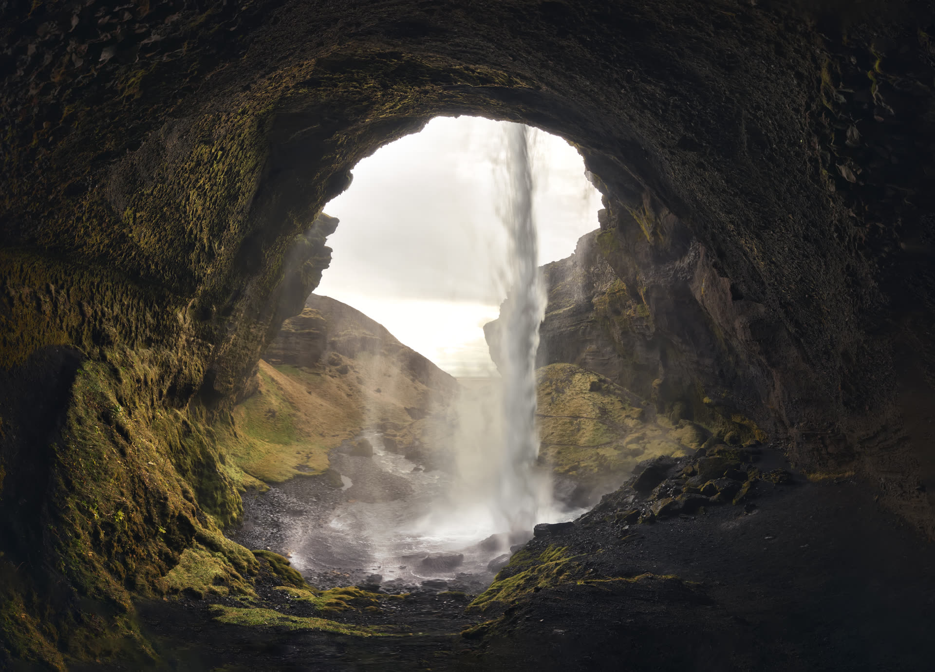 Panorámica desde el interior de la cascada Kvernufoss, sur de Islandia — luz entrando por la abertura de la cueva
